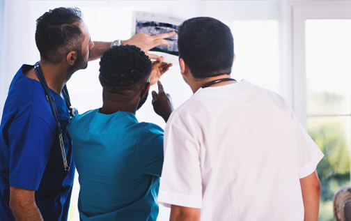 Three doctors discussing x-ray